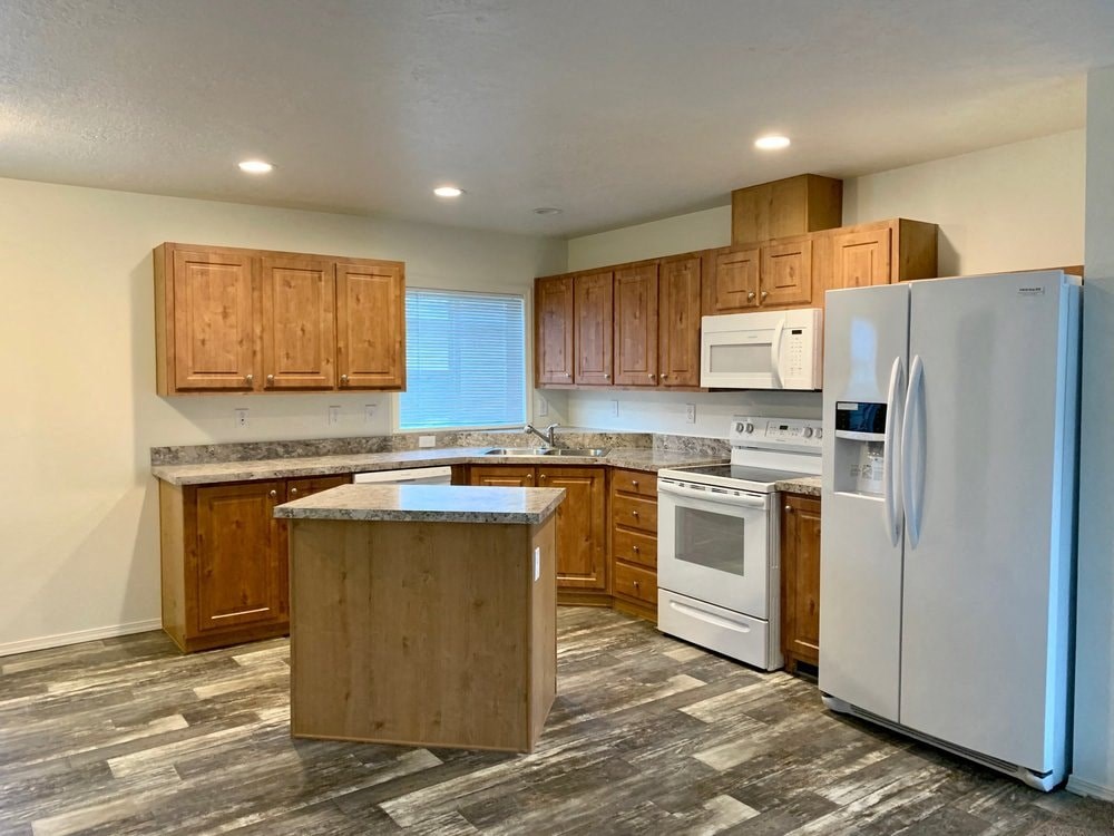 an empty kitchen with a refrigerator and a sink