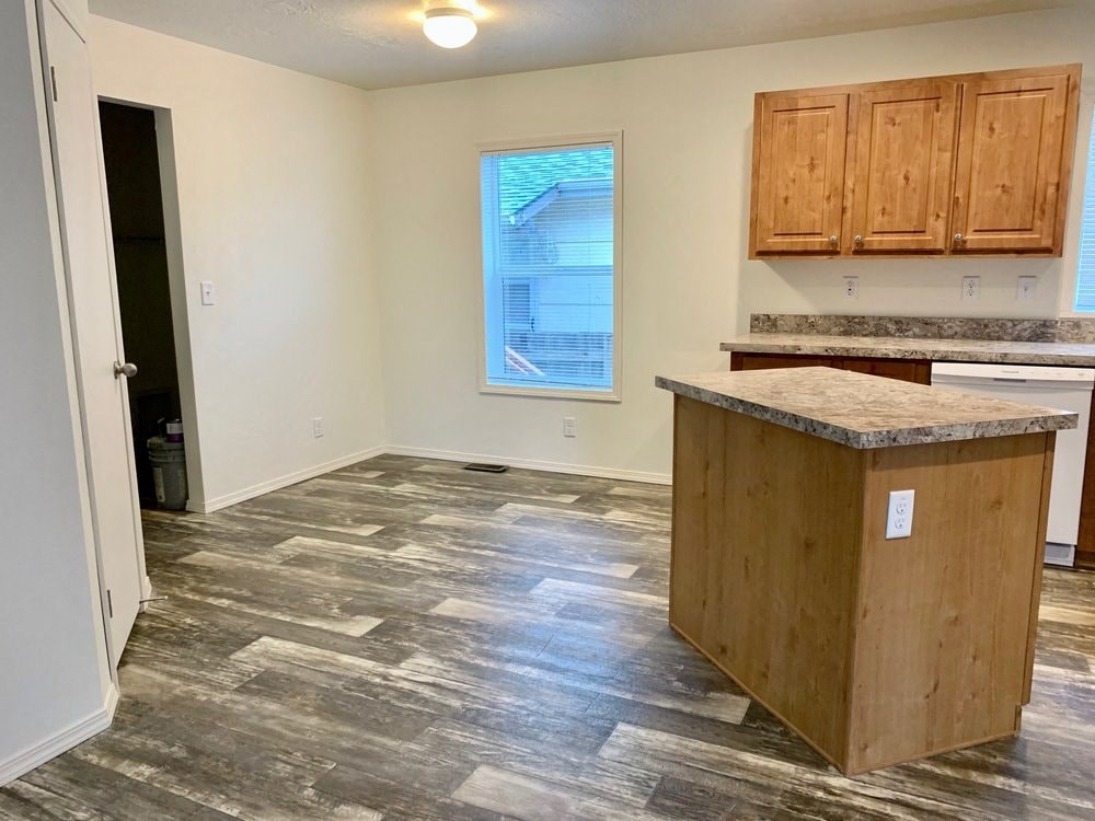 an empty kitchen with a island in the middle of it