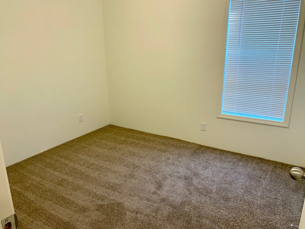 a room with a carpeted floor and a window