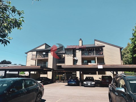 A parking lot in front of a building with the word "RODVAN" on it.