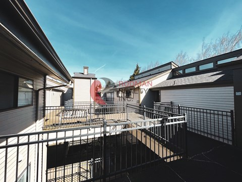 A balcony with a metal railing and a building with a sign that reads "HUDSON".