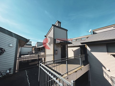 A building with a sign that says "REAL ESTATE" is seen from a balcony.