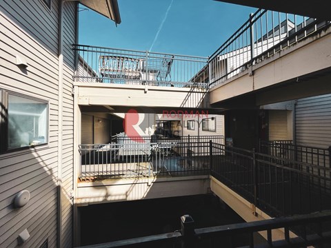 A balcony with a table and chairs is seen from above.
