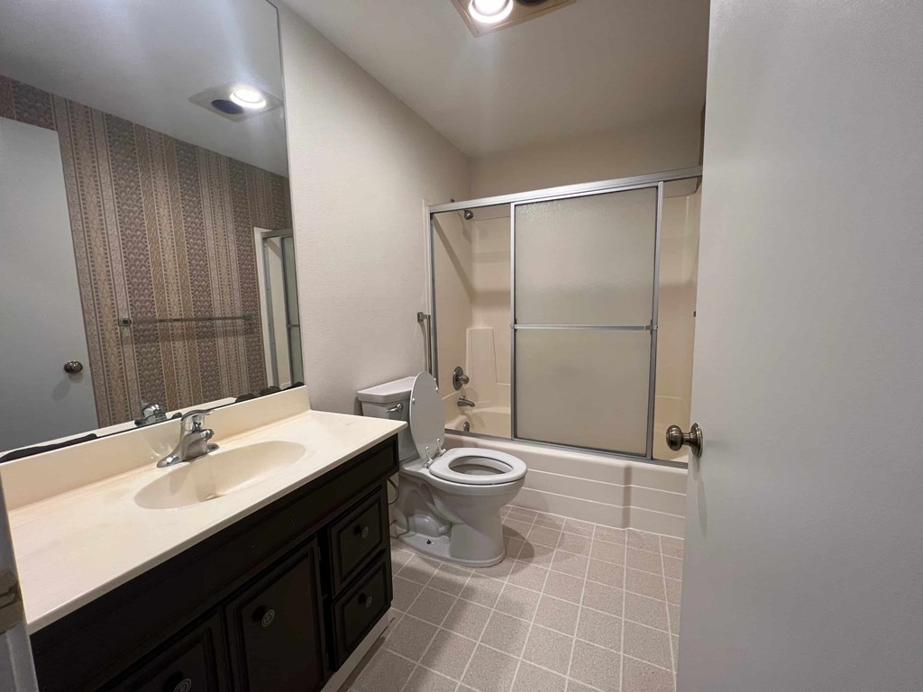 a bathroom with a toilet and a sink and a shower