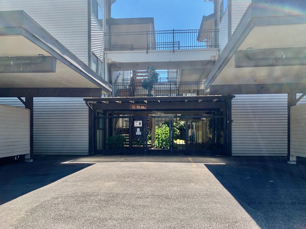 a view of the entrance of a building with a driveway and a balcony