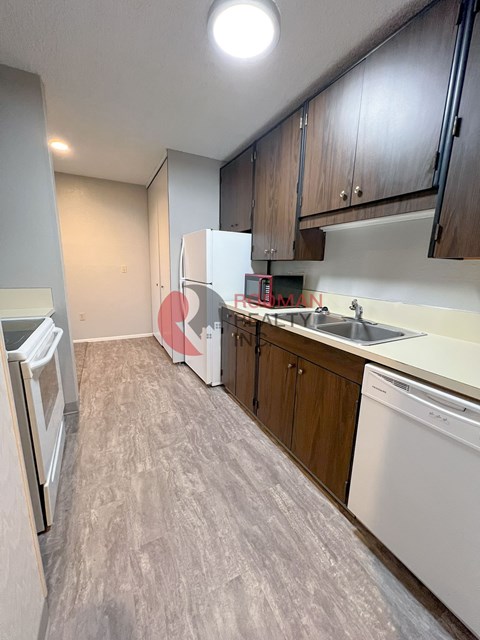 A kitchen with a white fridge and a white dishwasher.