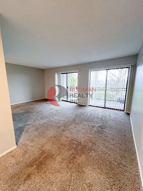 A carpeted room with a sign that says "Rodman Realty Inc.".