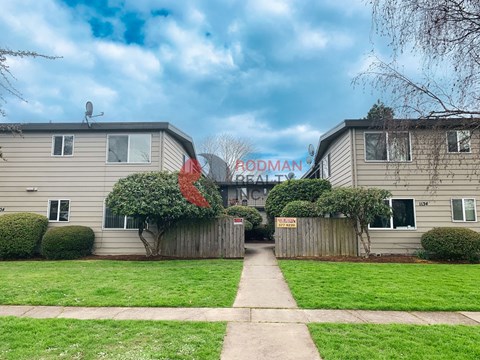 A residential area with two houses and a sign that says "Rodman Realty".