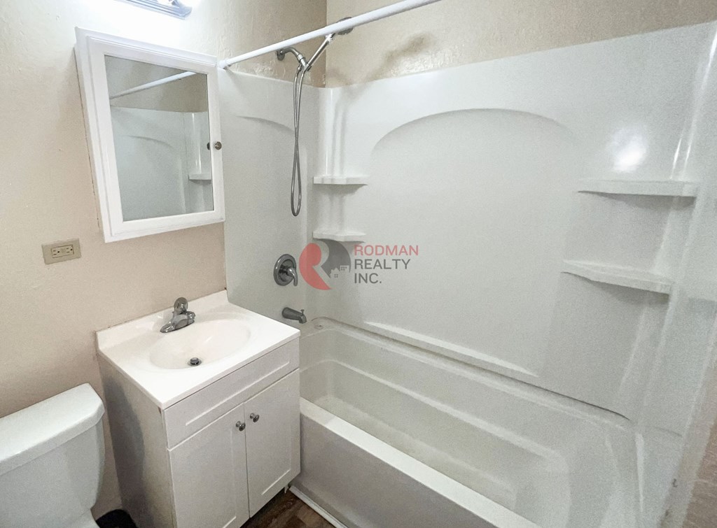 A white bathroom with a toilet, sink, and bathtub.