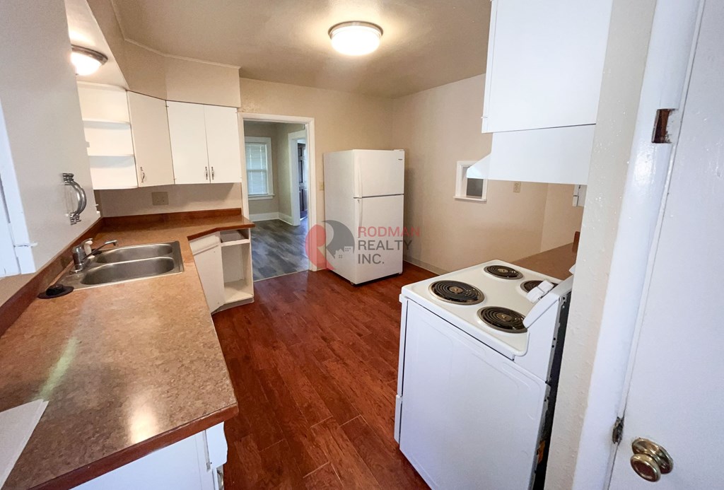 A kitchen with a stove top oven and a sink.
