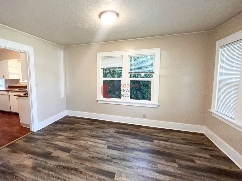 A room with a window and a wooden floor.