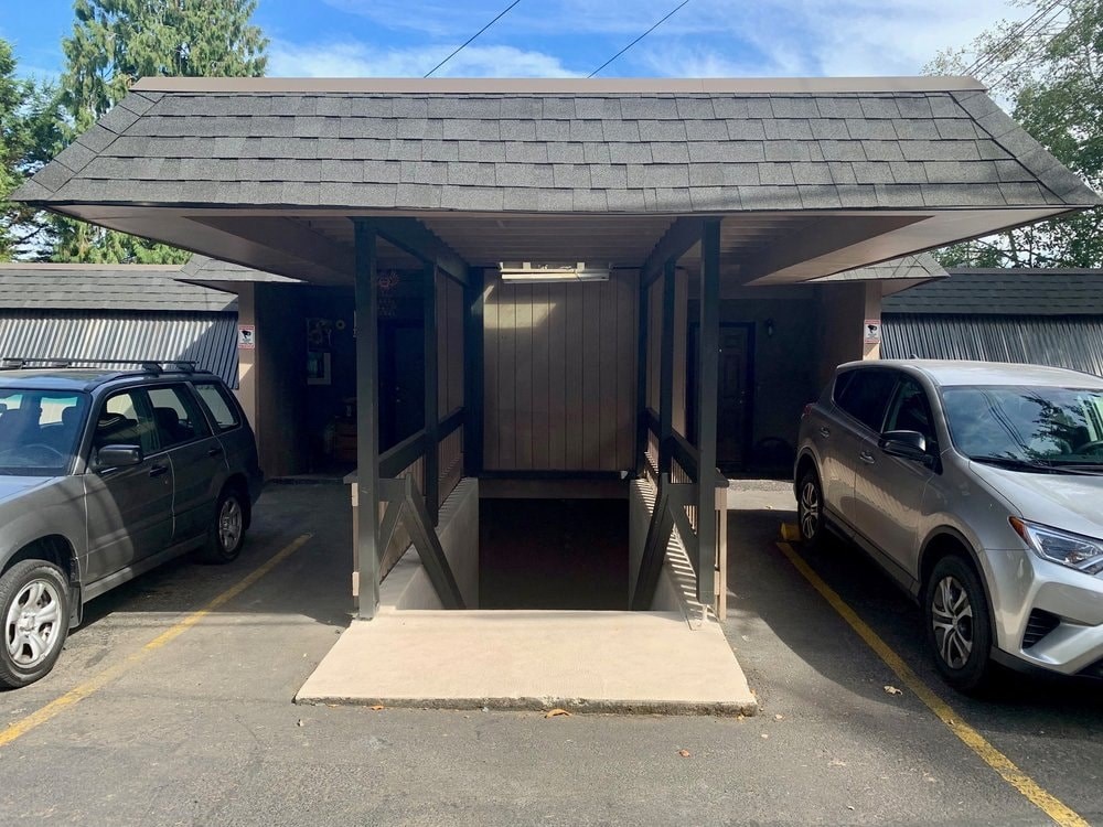 a parking garage with two cars parked in front of it