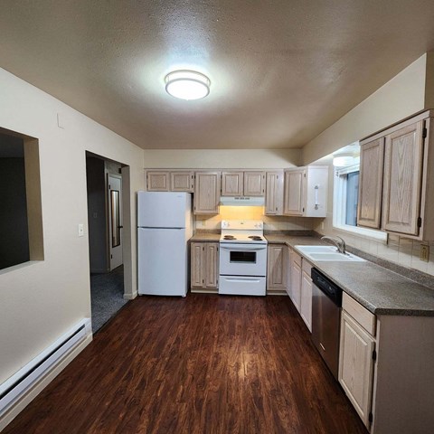 a kitchen with wooden floors and white appliances