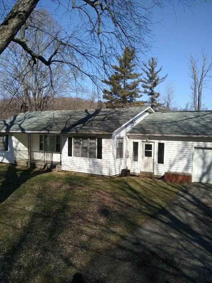 a white house with a gray roof and a yard