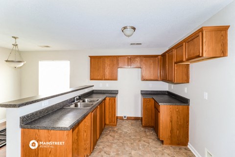 a kitchen with wood cabinets and granite counter tops