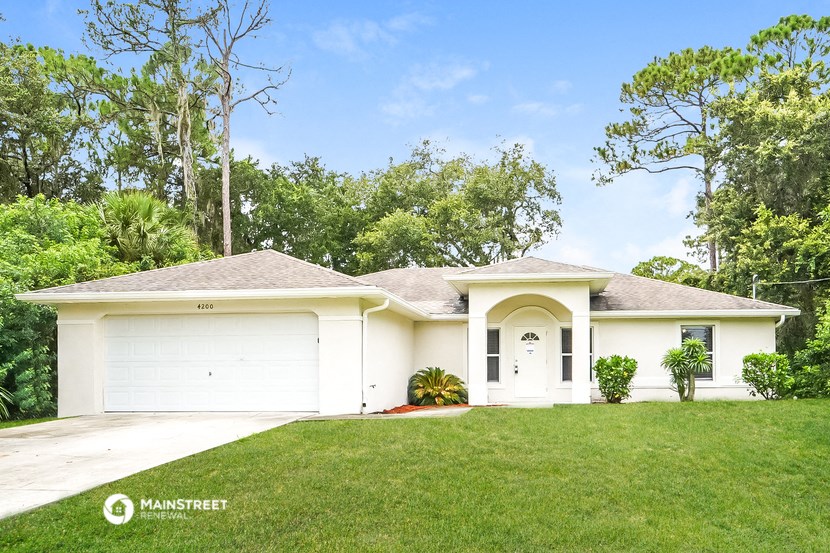 a white house with a lawn and a garage door