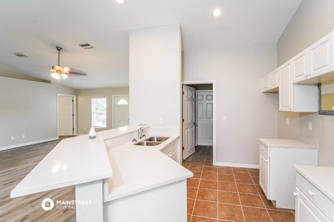 an open kitchen with white counter tops and a sink