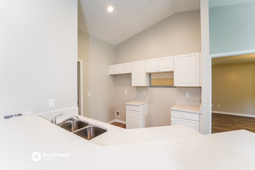 a kitchen with white cabinets and a sink