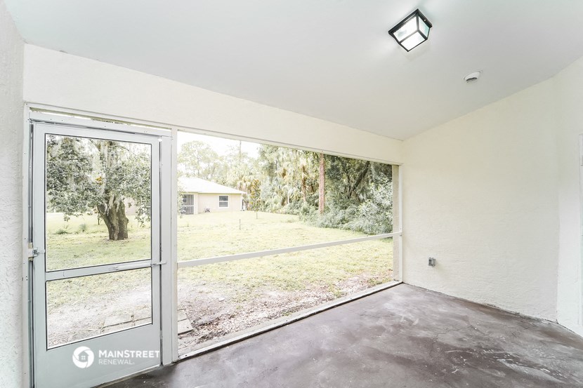 a living room with a large window and a door to a yard