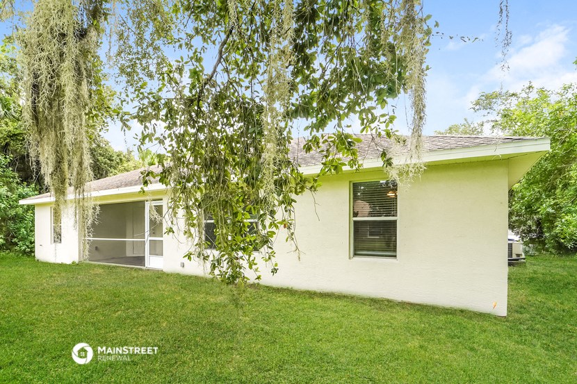 a small white house with a tree in front of it