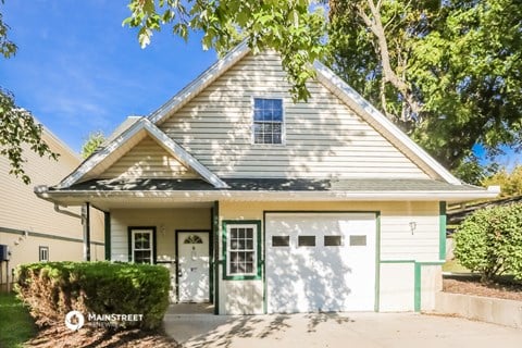 a white and green house with a garage door