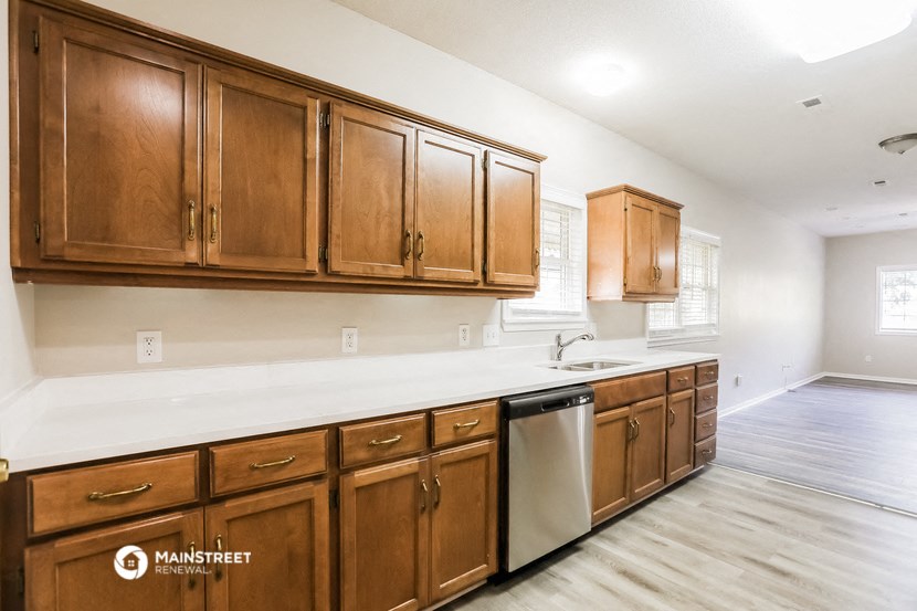 a kitchen with wooden cabinets and a white counter top and a dishwasher
