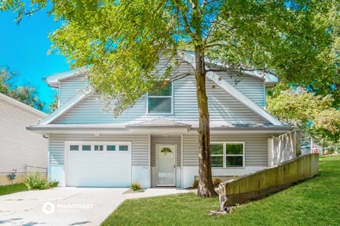 a blue and white house with a tree in front of it