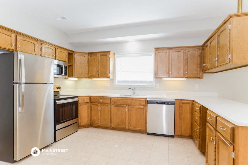 a kitchen with wooden cabinets and stainless steel appliances