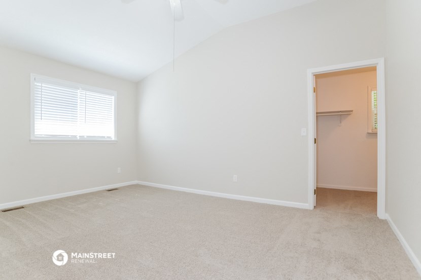 a bedroom with a closet and a door to a bathroom