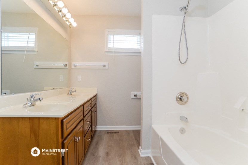 a bathroom with a tub and a sink and a shower