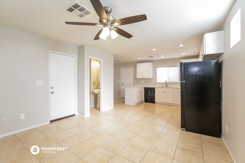 an empty kitchen with a ceiling fan and tiled floors