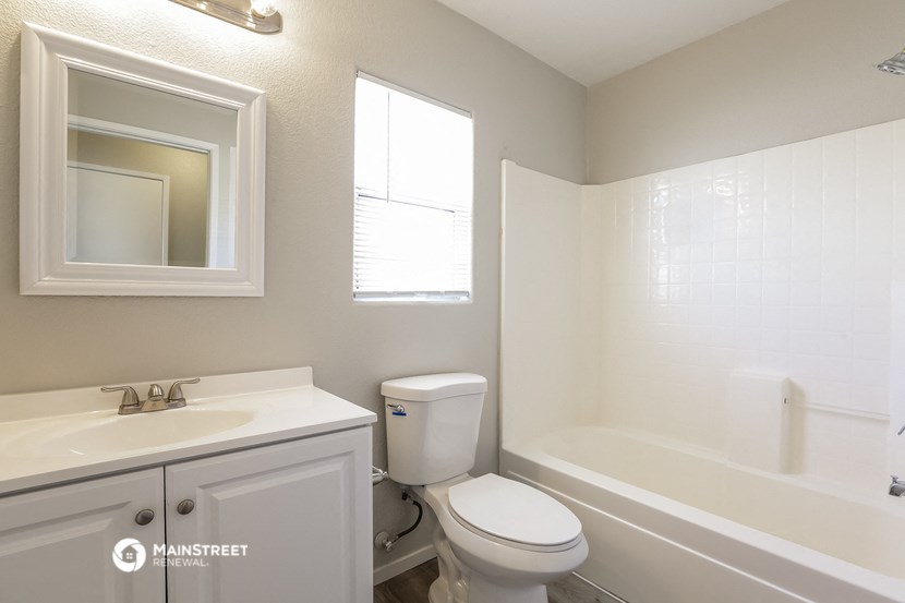 a bathroom with a toilet and a tub and a sink