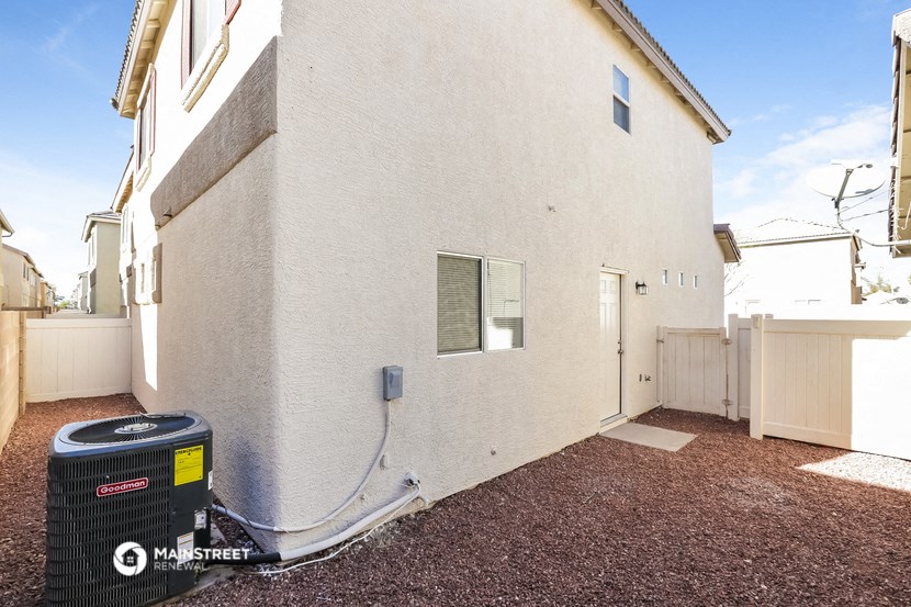 a side view of a white house with a trash can