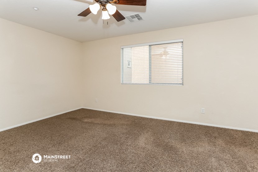 the spacious living room of a manufactured home with carpet and a ceiling fan