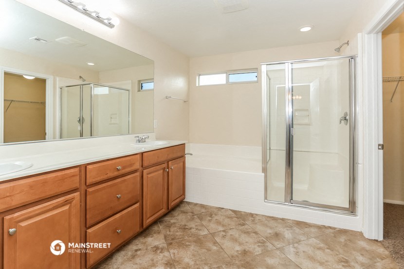 a bathroom with a shower and a sink and a mirror