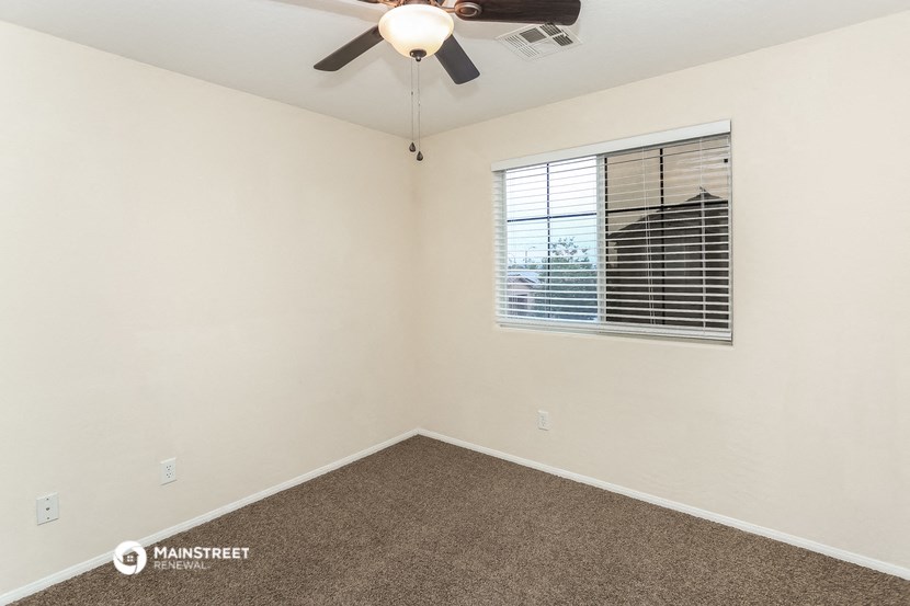 a bedroom with a ceiling fan and a window