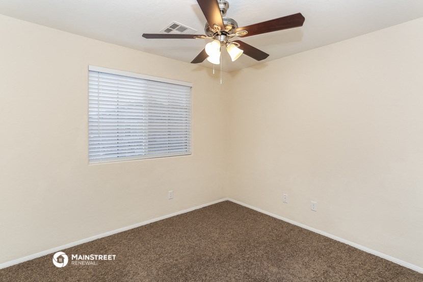 the bedroom has a ceiling fan and a window