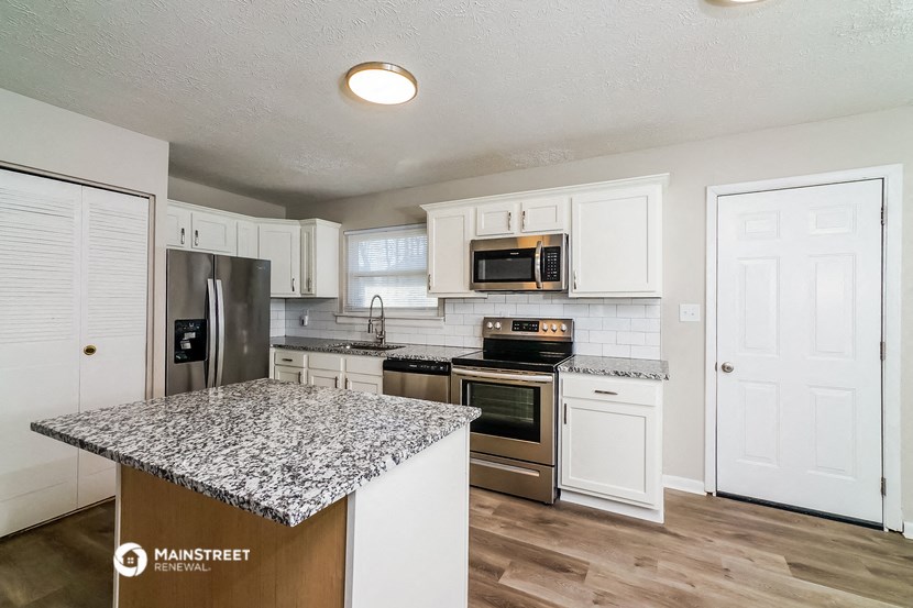 a kitchen with white cabinets and a granite counter top