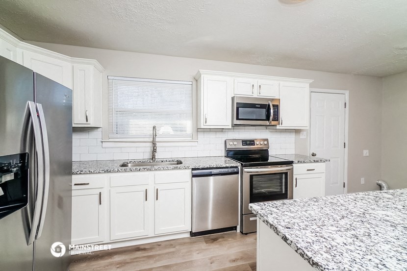 a kitchen with white cabinets and stainless steel appliances