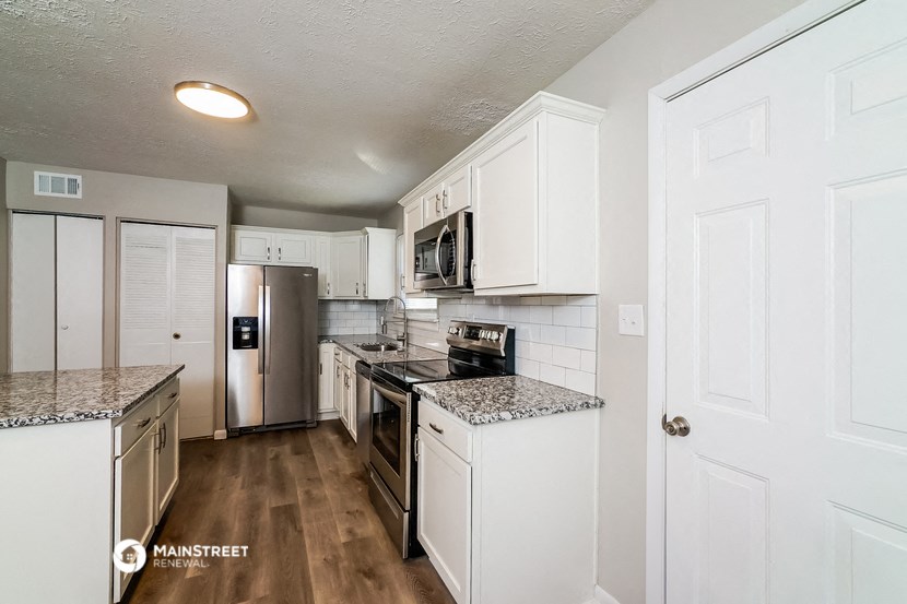 a kitchen with white cabinets and stainless steel appliances