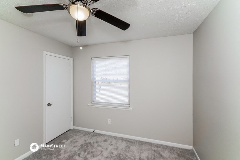 a bedroom with a ceiling fan and a window