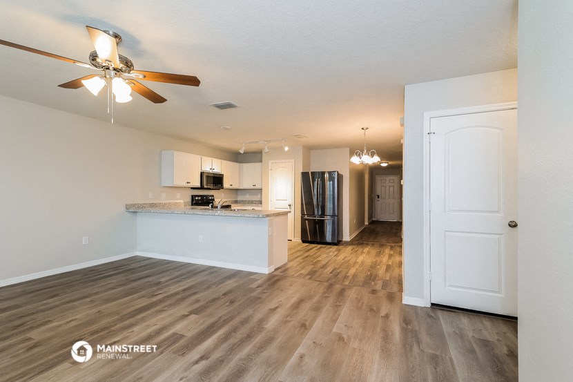 an open kitchen and living room with a ceiling fan