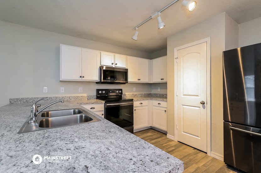 a kitchen with granite counter tops and black appliances