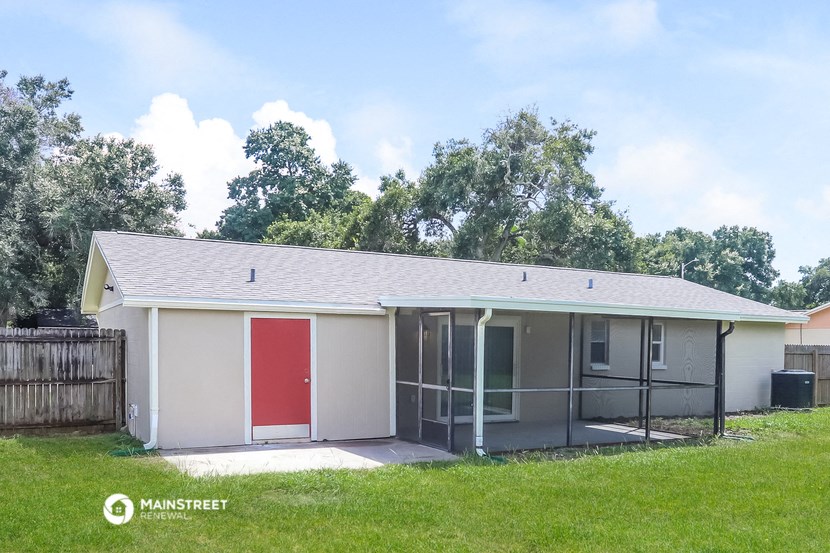 a small house with a red door and a screened in porch