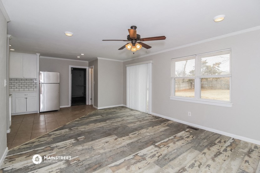 a living room with a ceiling fan and a kitchen