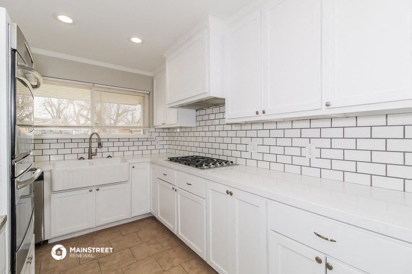 a white kitchen with white cabinets and white tile