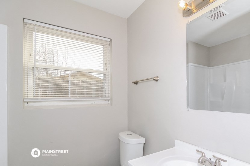 a bathroom with a window and a sink and a mirror