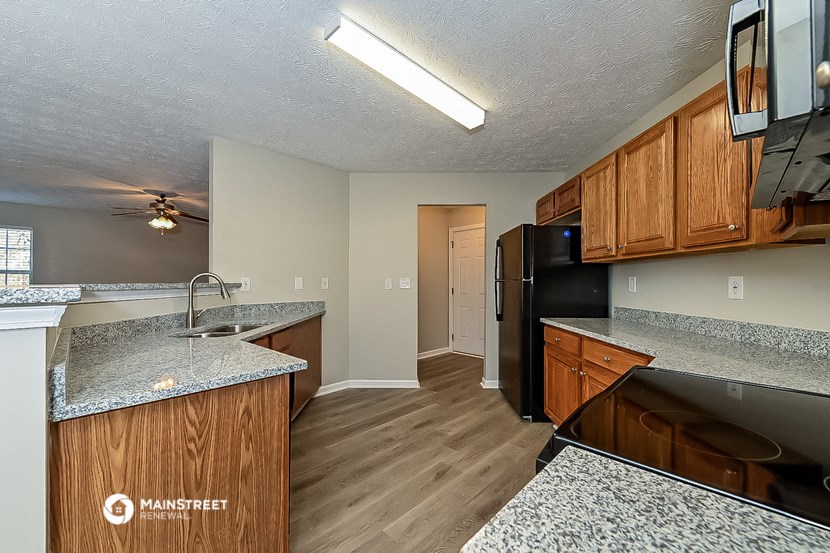 a kitchen with granite counter tops and a black refrigerator