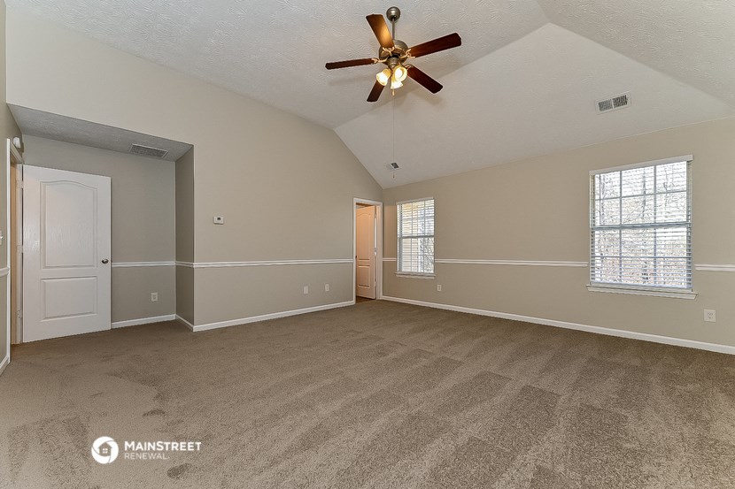 the living room of an empty house with a ceiling fan