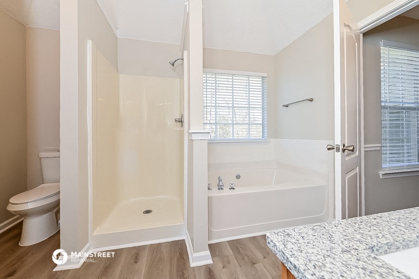 a bathroom with a tub and a toilet and a sink